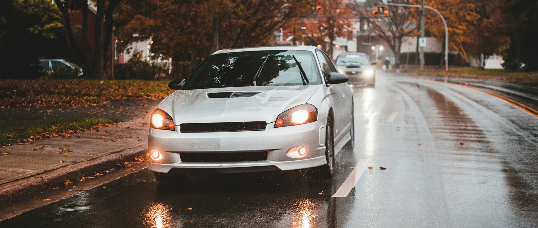 Auto auf nasser Fahrbahn im Herbst.